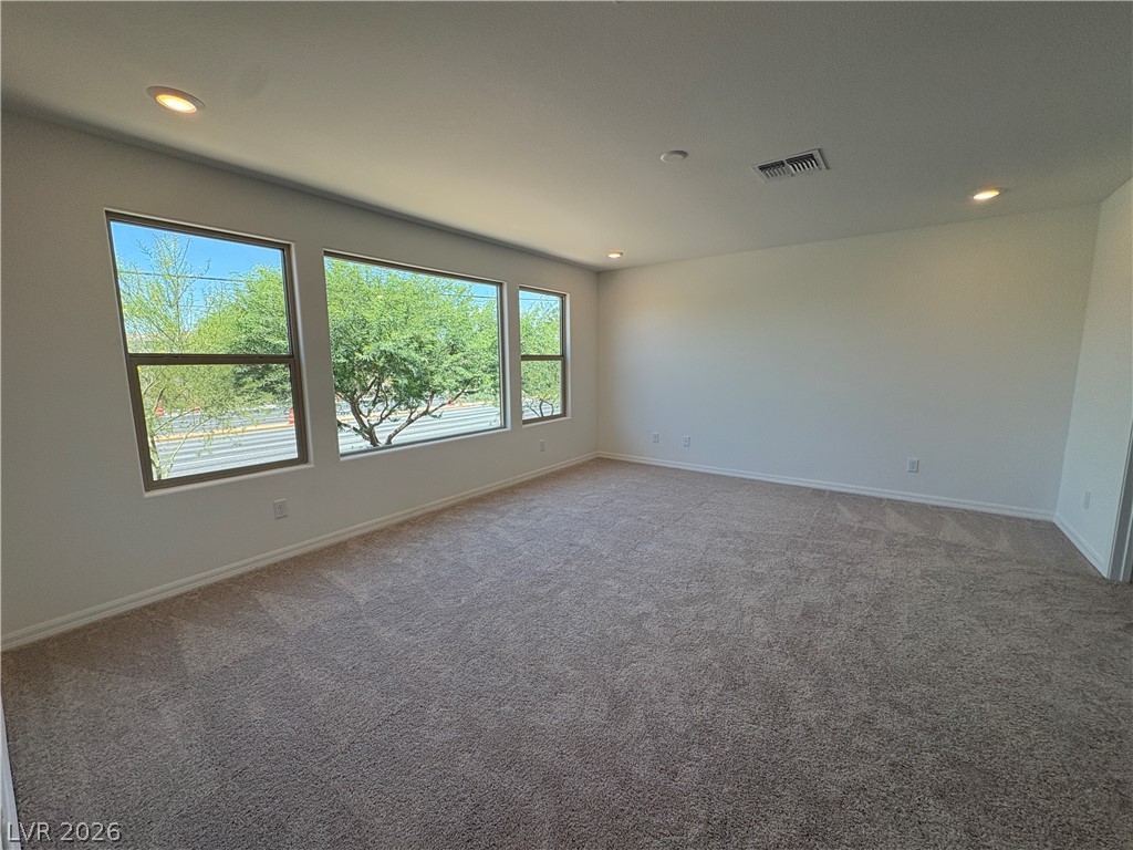 8677 South Indigo Springs Road Las Vegas, NV 89139 - Photo 7 of 9 Natural light streams into this generously proportioned room, offering serene views through multiple windows.