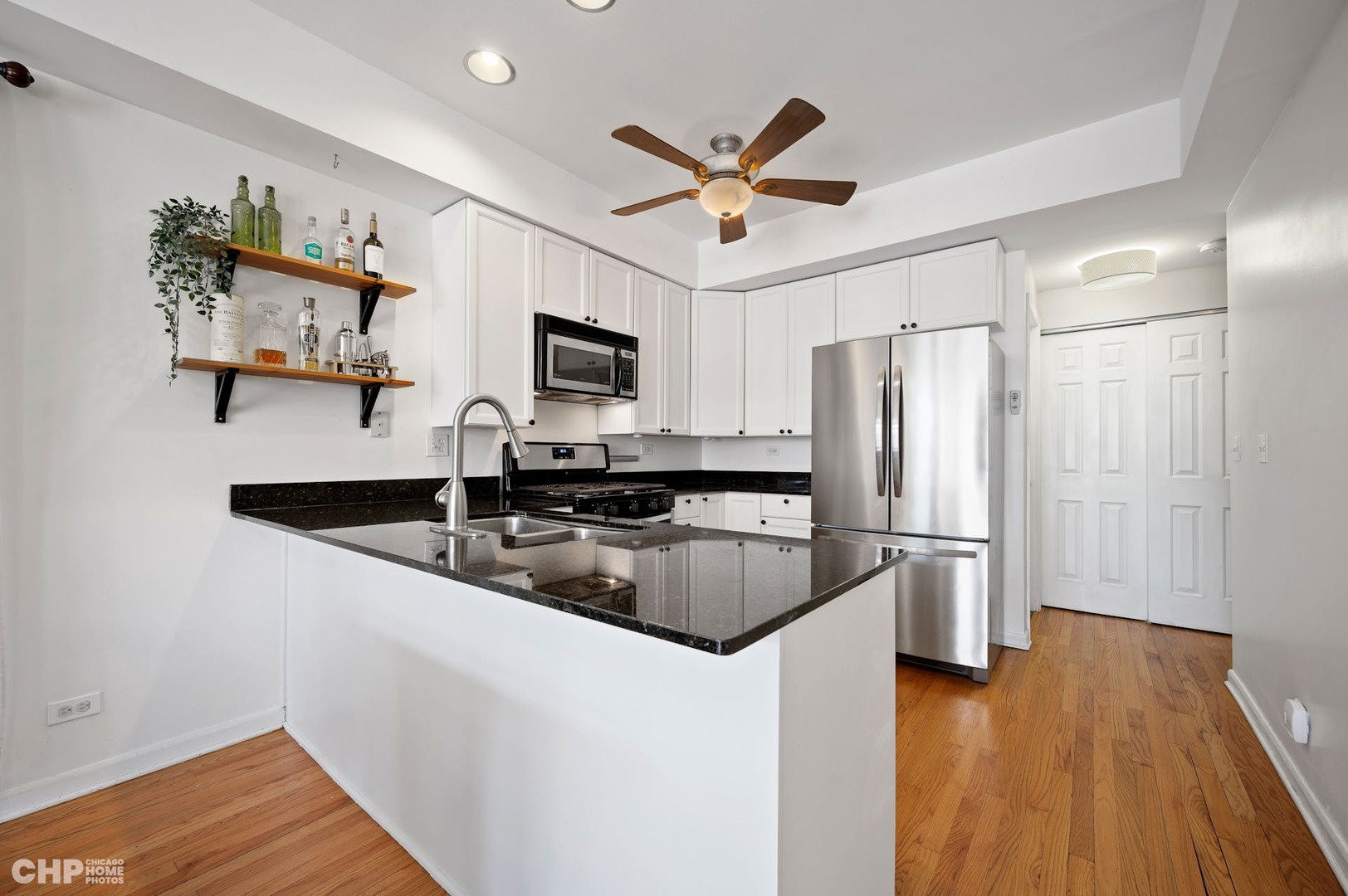 2349 West Harrison Street, Unit 3 Chicago, IL 60612 - Photo 11 of 26 a kitchen with kitchen island a counter top space appliances and a ceiling fan