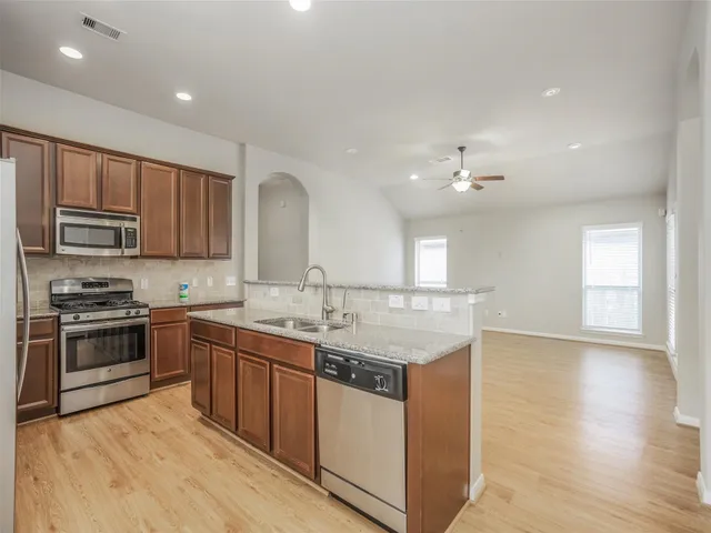 a kitchen with stainless steel appliances granite countertop a sink stove and refrigerator