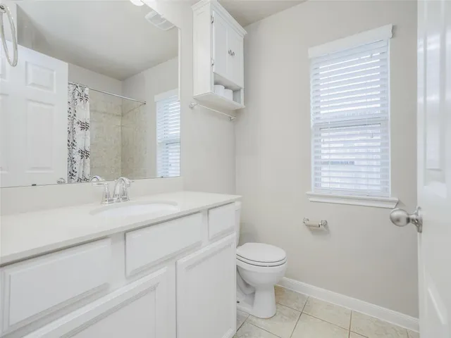 a bathroom with a granite countertop sink a toilet and a mirror