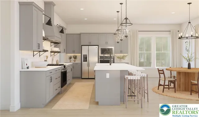 a kitchen with kitchen island a stove a refrigerator a sink dishwasher a dining table and chairs with wooden floor