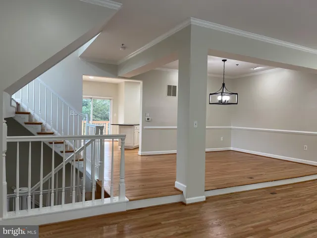 a kitchen with granite countertop white cabinets and a wooden floor