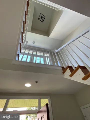 a view of an empty room with wooden floor and cabinet