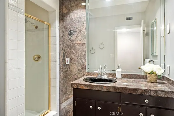 a bathroom with a granite countertop sink and a mirror