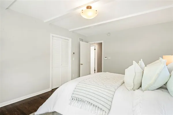 a bedroom with a white bed and a chandelier
