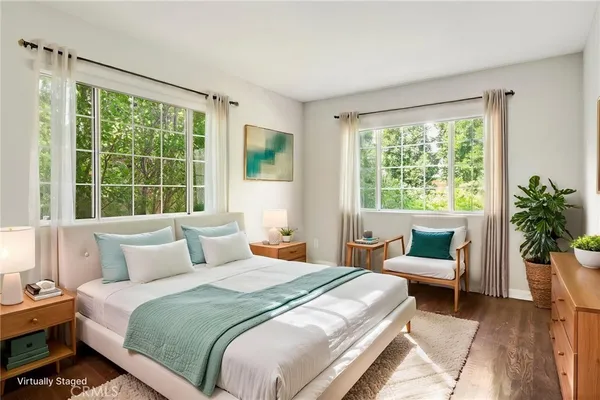 a view of an empty room with wooden floor and windows