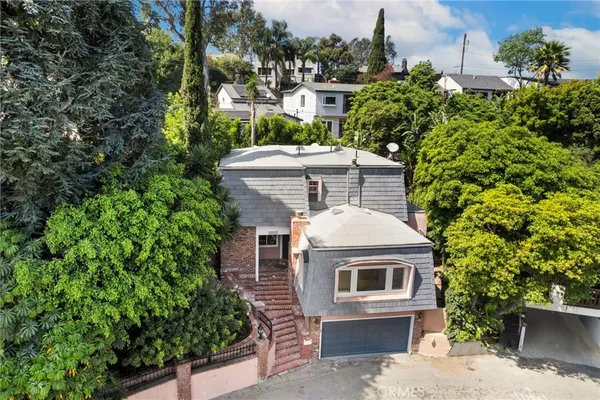 an aerial view of a house with a yard and large tree