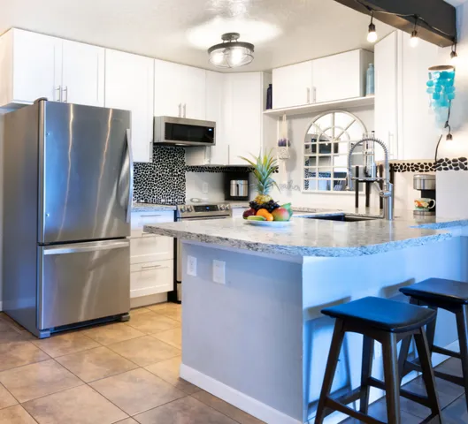 a kitchen with stainless steel appliances a refrigerator a stove a sink and a counter