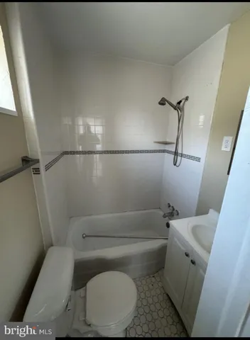a white toilet sitting next to a bath tub