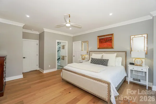 a spacious bedroom with a bed and a chandelier