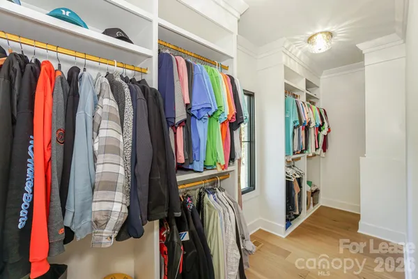 a view of walk in closet with clothes