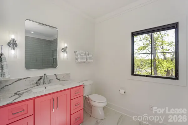 a bathroom with a granite countertop toilet sink and mirror