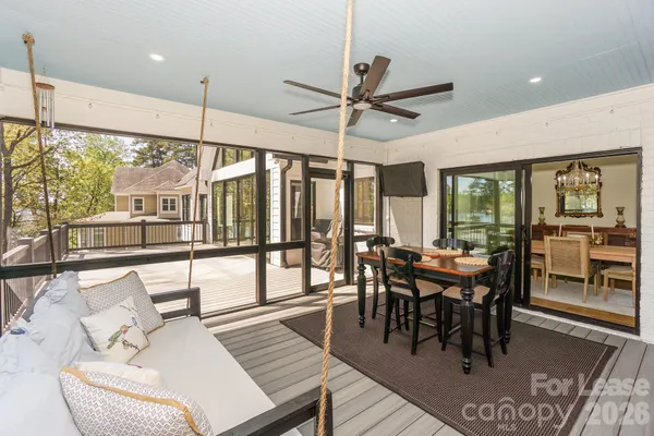 a view of a dining room and livingroom with furniture wooden floor a chandelier