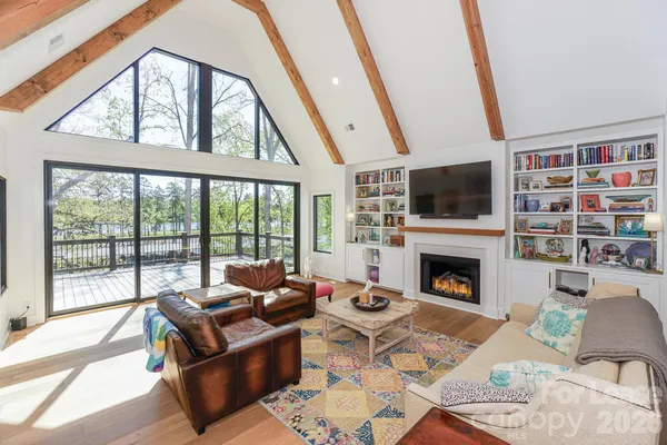 a living room with furniture a fireplace and a floor to ceiling window