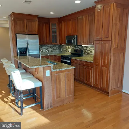 a kitchen with stainless steel appliances granite countertop a sink refrigerator and cabinets