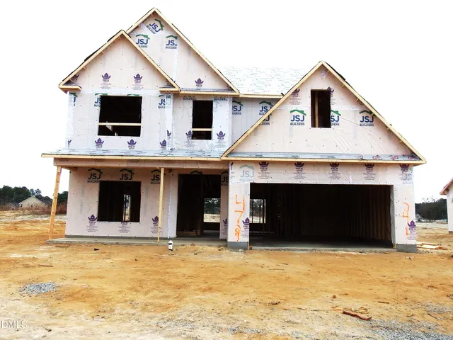 a front view of a house with large trees