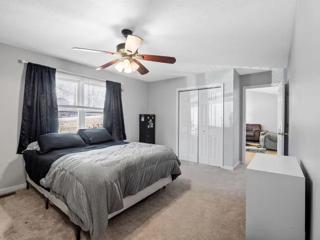 a bedroom with a large bed and a chandelier