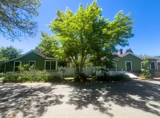 a view of a yard in front of a house with large tree