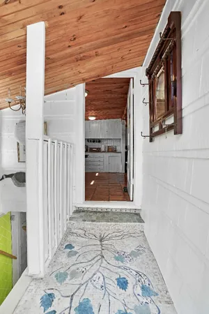 a view of a patio with table and chairs and floor to ceiling window with wooden fence