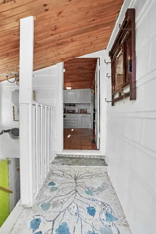 a view of a patio with table and chairs and floor to ceiling window with wooden fence