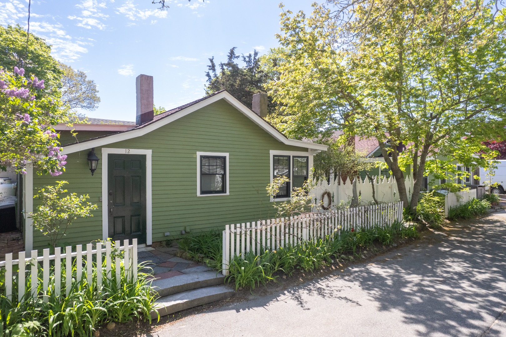 12 Maple Avenue Oak Bluffs, MA 02557 - Photo 3 of 55 a front view of a house with a garden