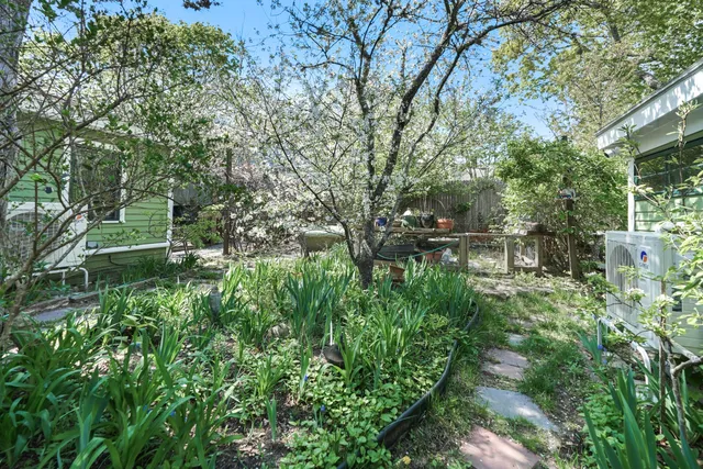 a view of a house with a yard and garden