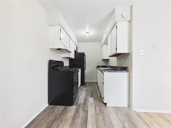 a kitchen with cabinets and wooden floor