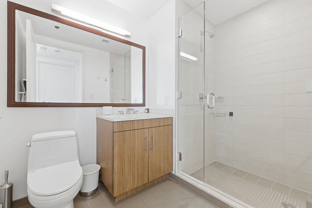 580 Washington Street, Unit 901 Boston, MA 02111 - Photo 14 of 30 a bathroom with a toilet a sink and shower