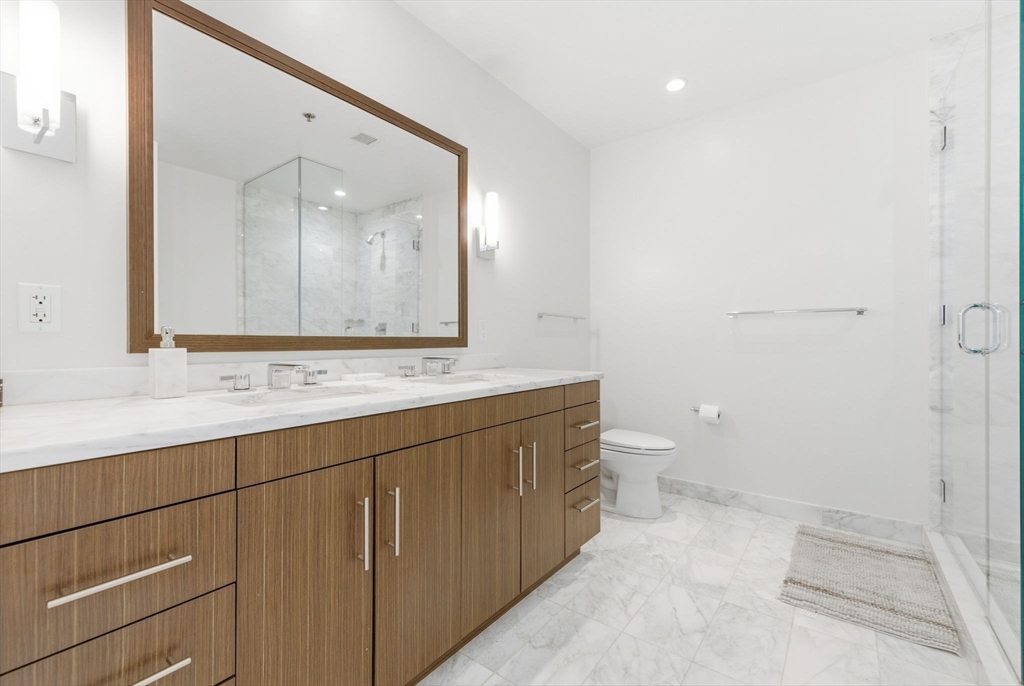 580 Washington Street, Unit 901 Boston, MA 02111 - Photo 15 of 30 a bathroom with a toilet sink and mirror