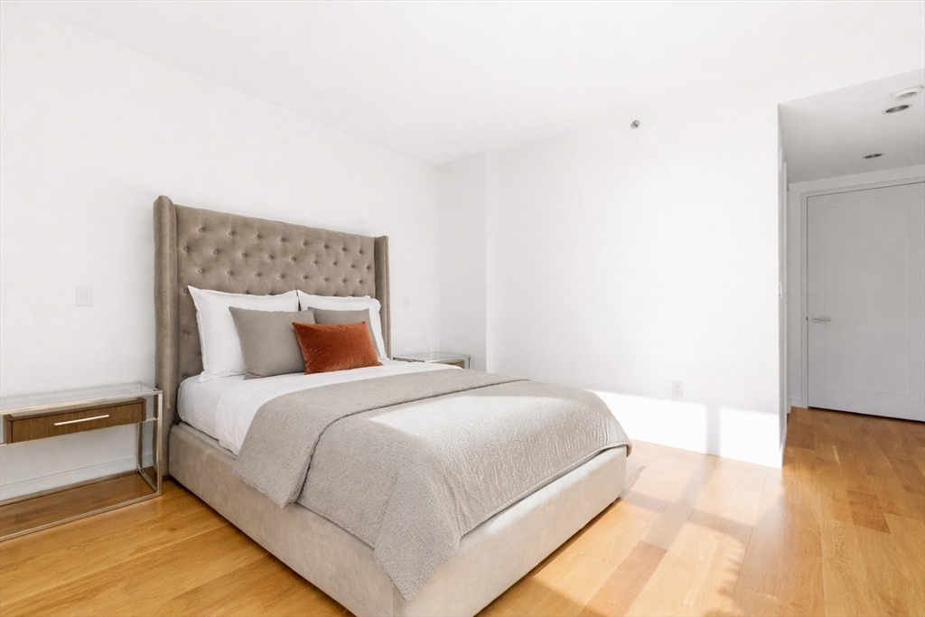 580 Washington Street, Unit 901 Boston, MA 02111 - Photo 19 of 30 a bed room with a bed and a night stand