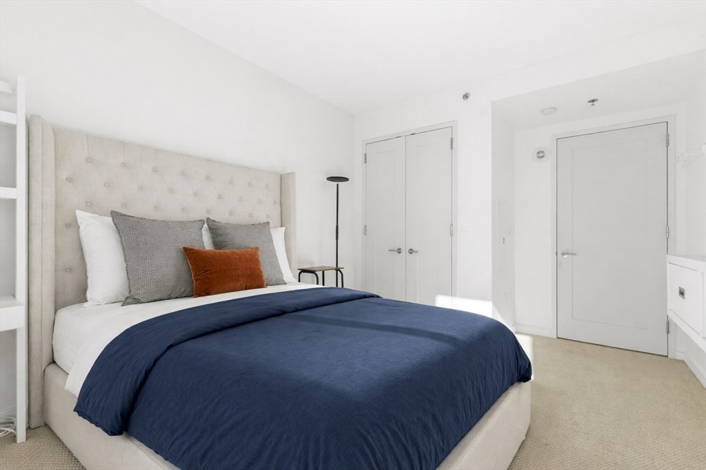 580 Washington Street, Unit 901 Boston, MA 02111 - Photo 21 of 30 a bedroom with a bed and a night stand