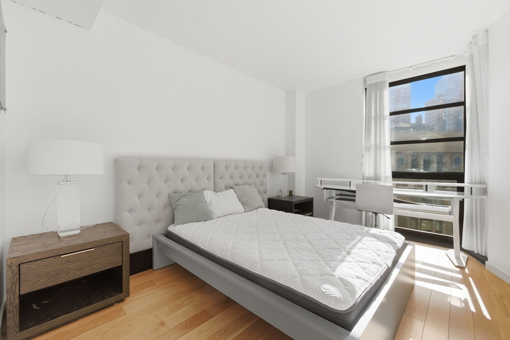 580 Washington Street, Unit 901 Boston, MA 02111 - Photo 22 of 30 a living room with a bed furniture and a flat tv screen