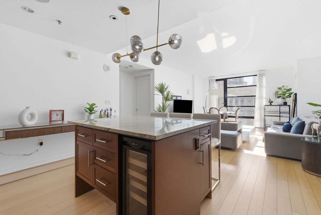 580 Washington Street, Unit 901 Boston, MA 02111 - Photo 6 of 30 a kitchen with a cabinets and living room