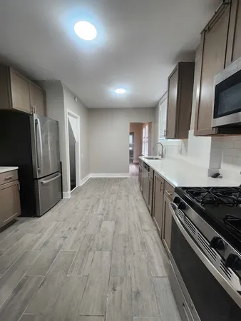 a kitchen with stainless steel appliances a refrigerator a stove a sink and a oven
