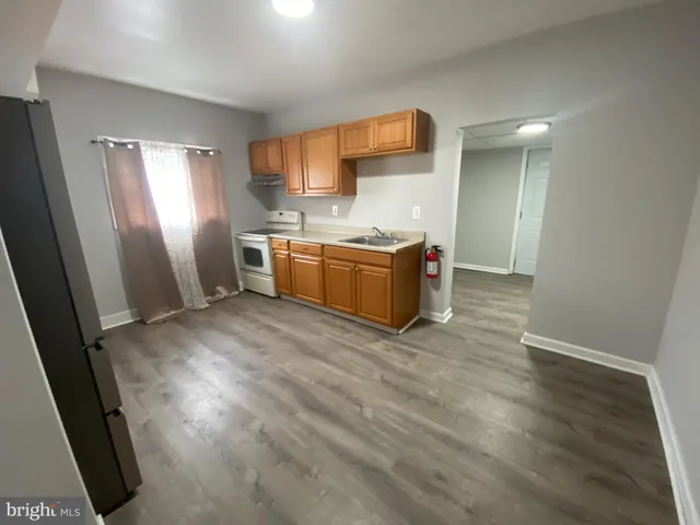 a kitchen with sink a refrigerator and wooden floor