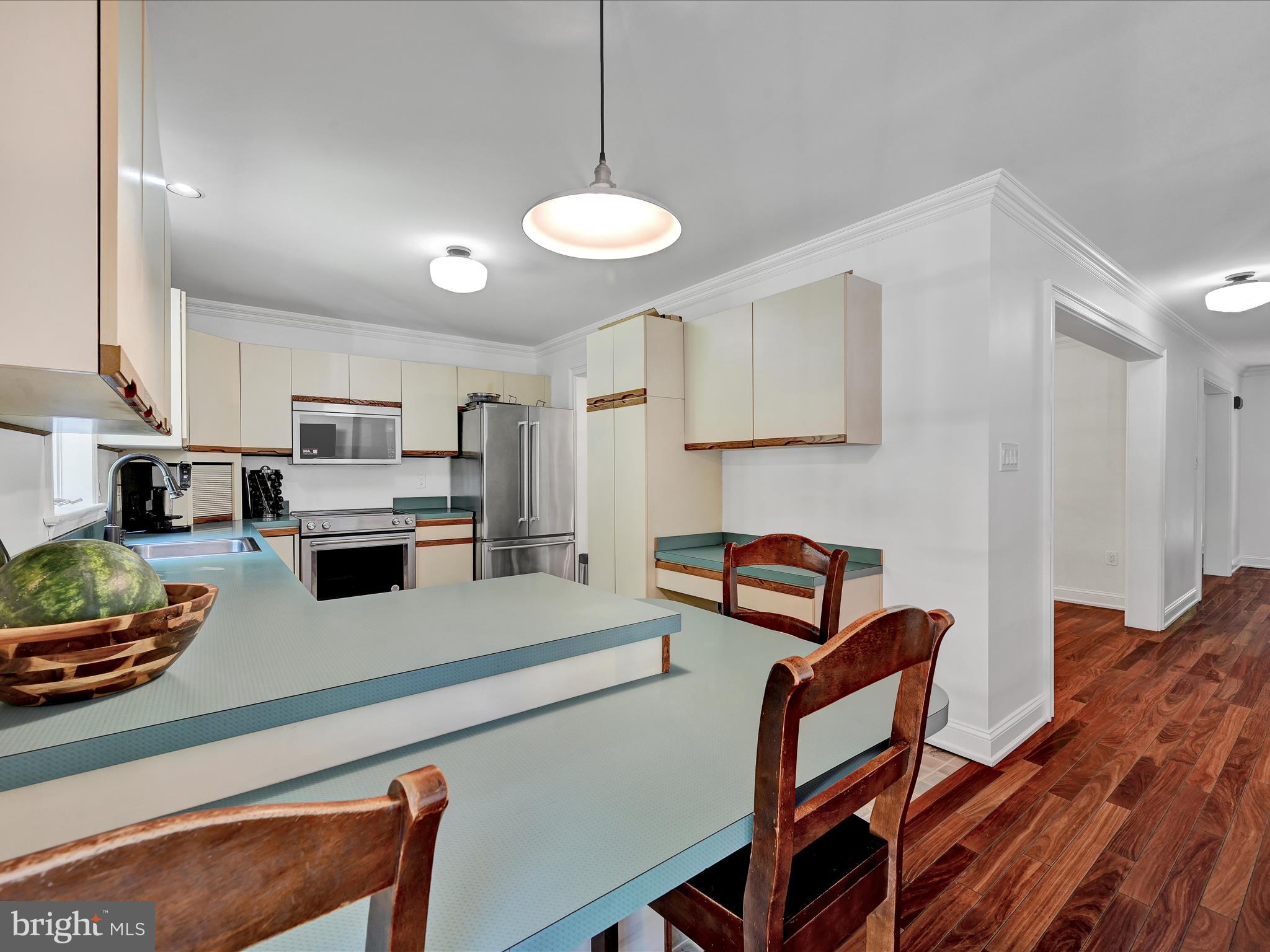 4018 Hillview Road Temple, PA 19560 - Photo 15 of 52 a kitchen with stainless steel appliances granite countertop a stove a refrigerator a sink a dining table and chairs with wooden floor
