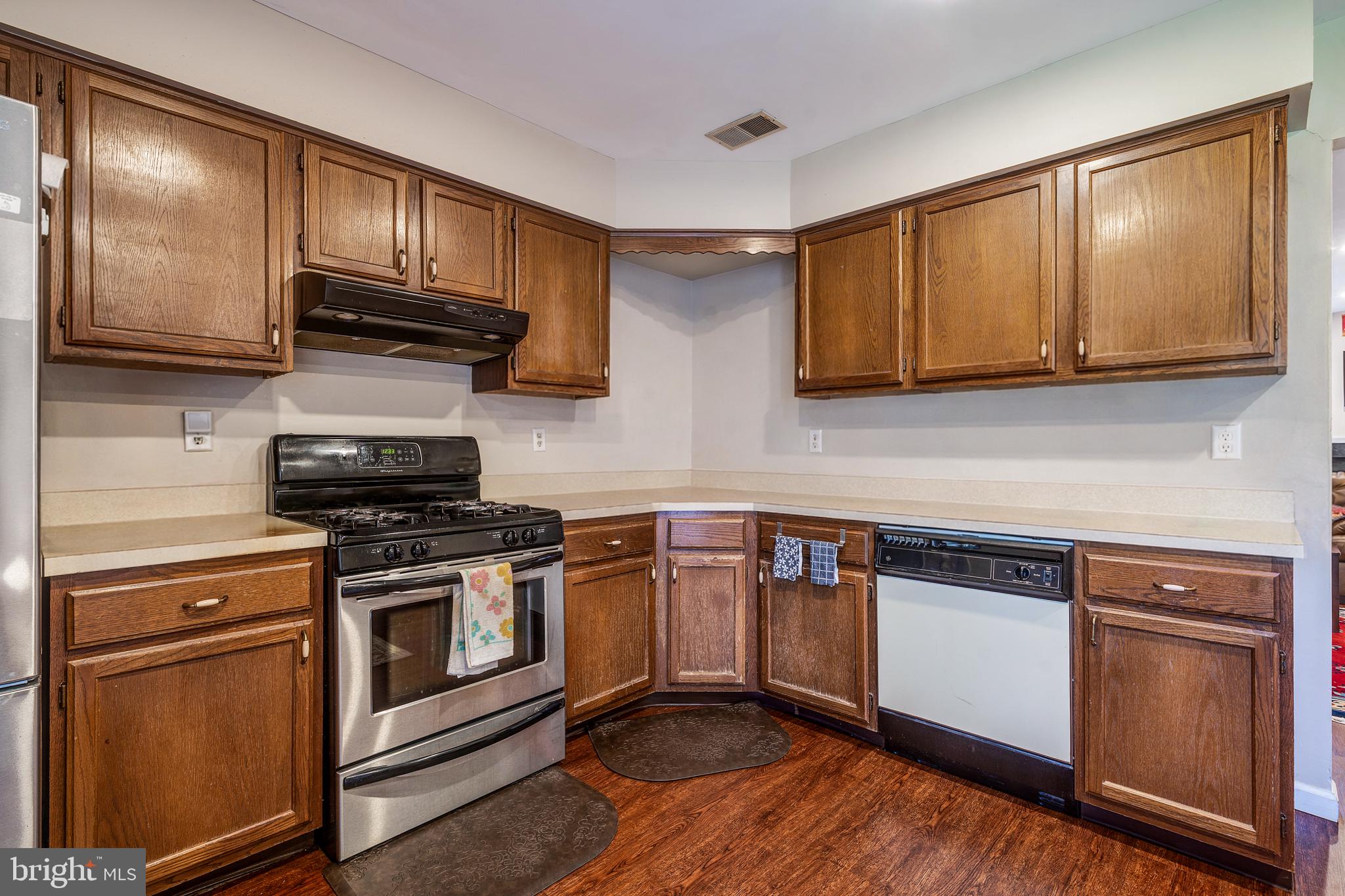 13-7 Stuart Drive Freehold, NJ 07728 - Photo 15 of 27 a kitchen with granite countertop wooden cabinets stainless steel appliances and a sink