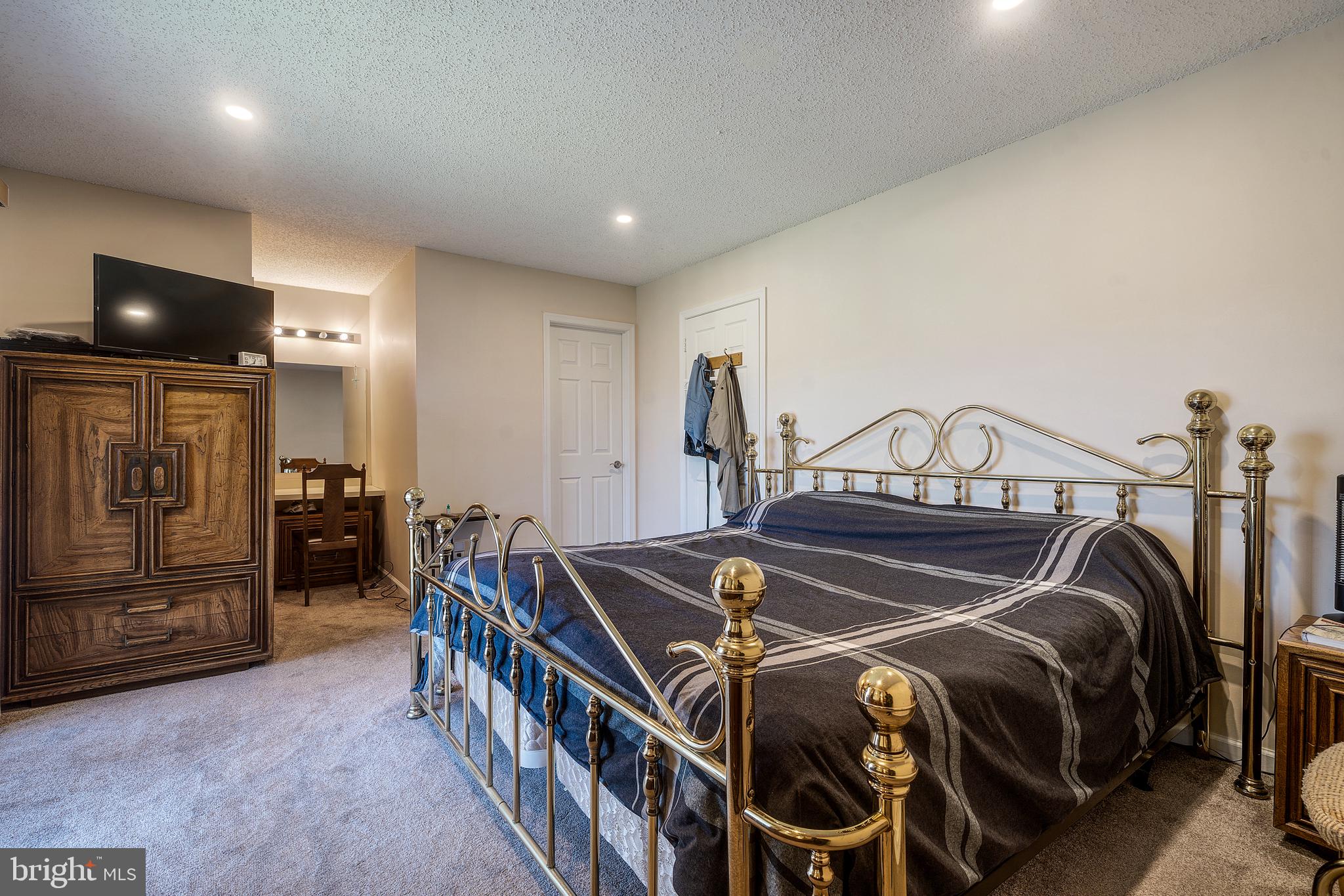 13-7 Stuart Drive Freehold, NJ 07728 - Photo 19 of 27 a bedroom with a bed and a tv
