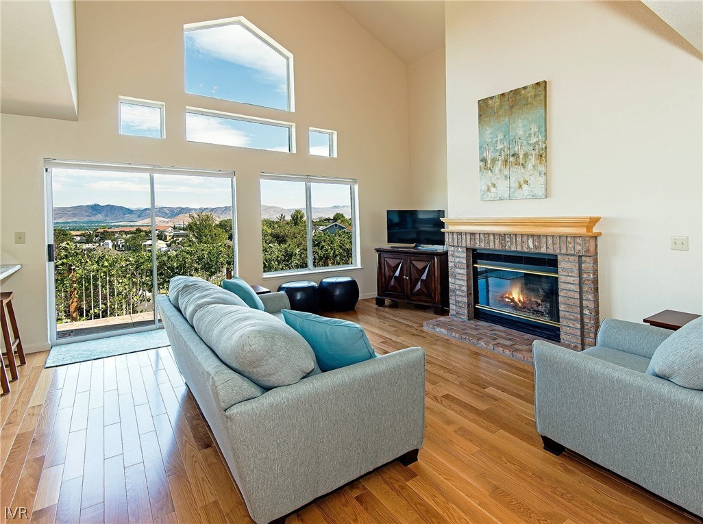 6182 Squires Lane Reno, NV 89519 - Photo 4 of 17 a living room with furniture a fireplace and a floor to ceiling window