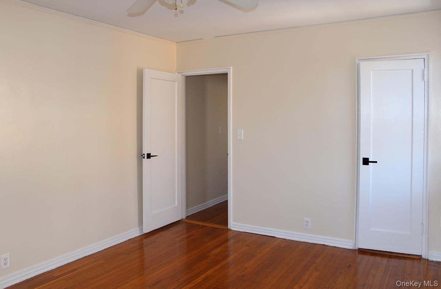 811 Bronx River Road, Unit 5A Yonkers, NY 10708 - Photo 16 of 18 Unfurnished bedroom featuring dark wood finished floors and ceiling fan