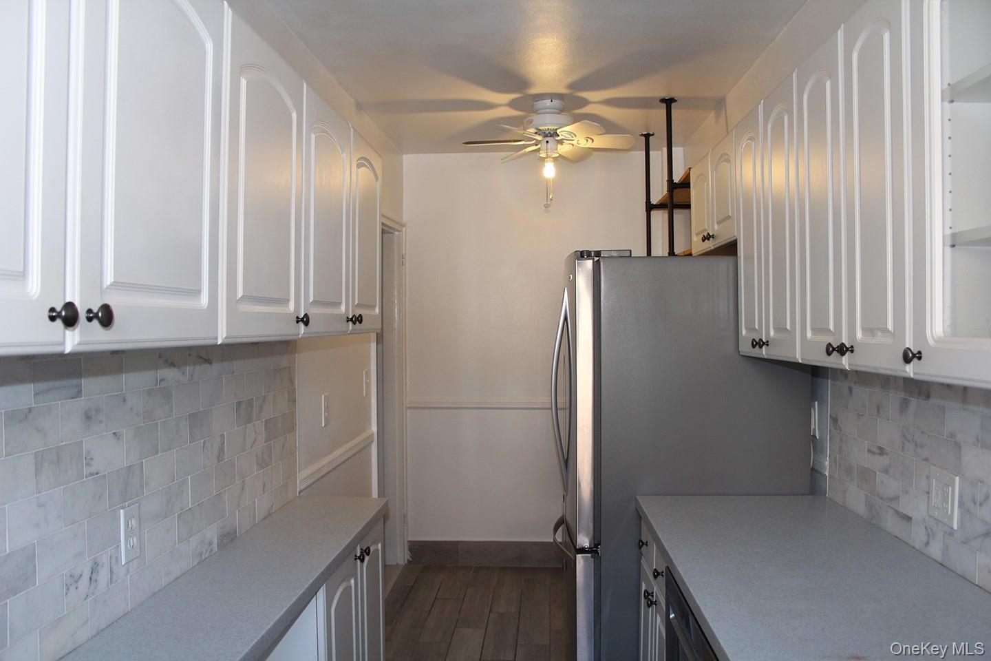 811 Bronx River Road, Unit 5A Yonkers, NY 10708 - Photo 3 of 18 Kitchen with tasteful backsplash, white cabinetry, light countertops, and a ceiling fan