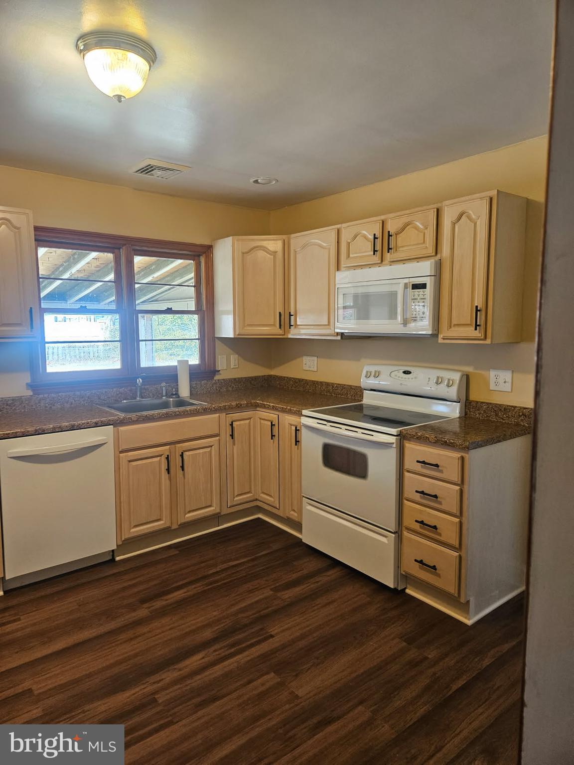 21 Manor Drive Dover, DE 19901 - Photo 6 of 24 a kitchen with wooden floors and white appliances