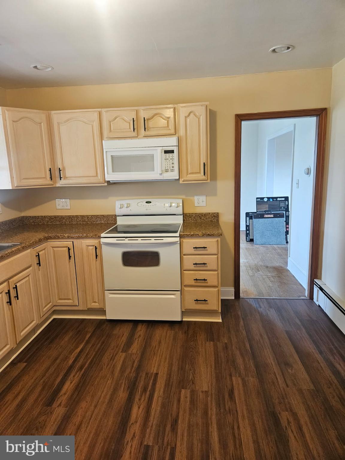 21 Manor Drive Dover, DE 19901 - Photo 10 of 24 a kitchen with wooden floors and white cabinets