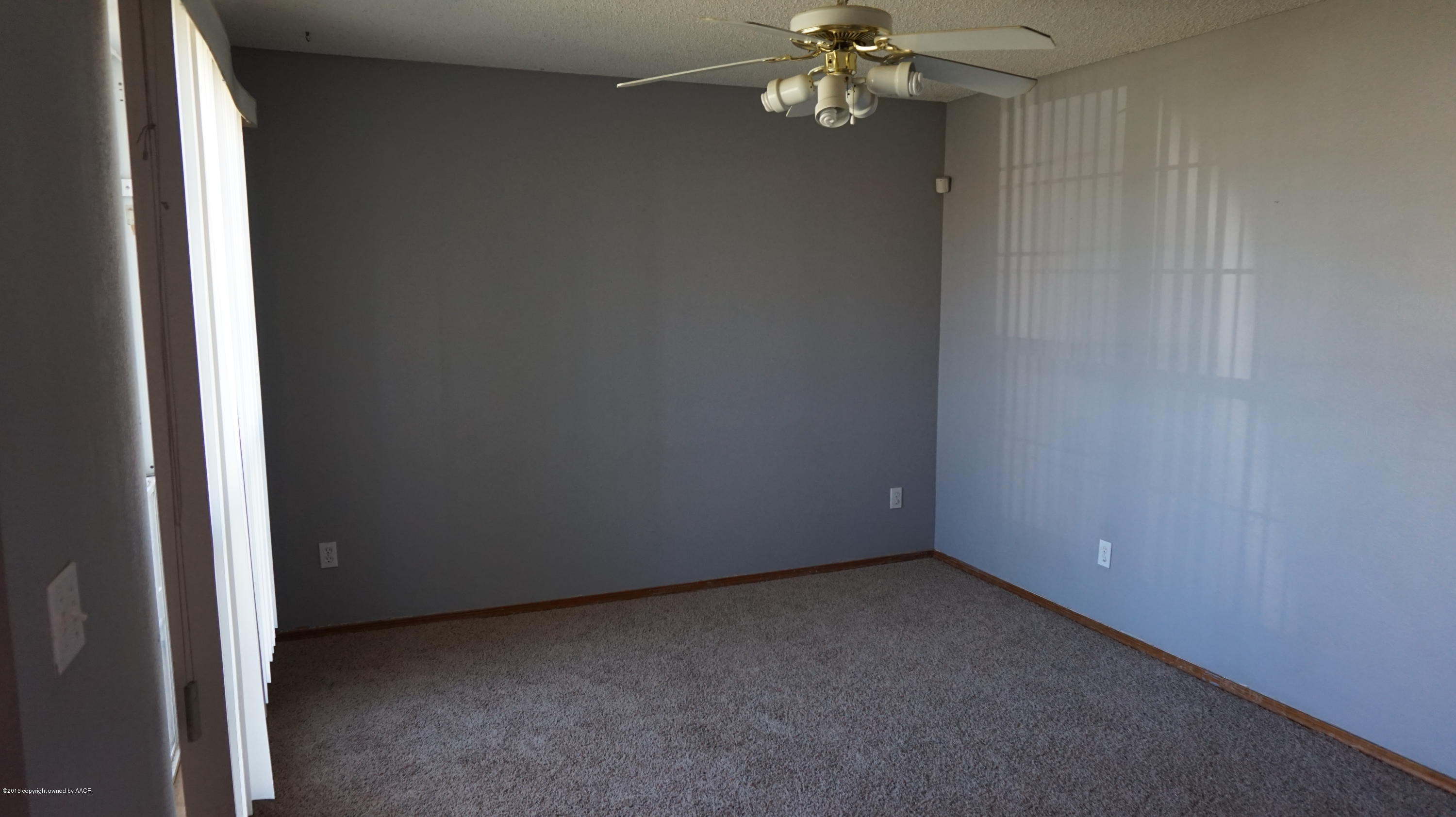 5228 Capulin Lane Amarillo, TX 79110 - Photo 4 of 16 an empty room with a chandelier fan and windows