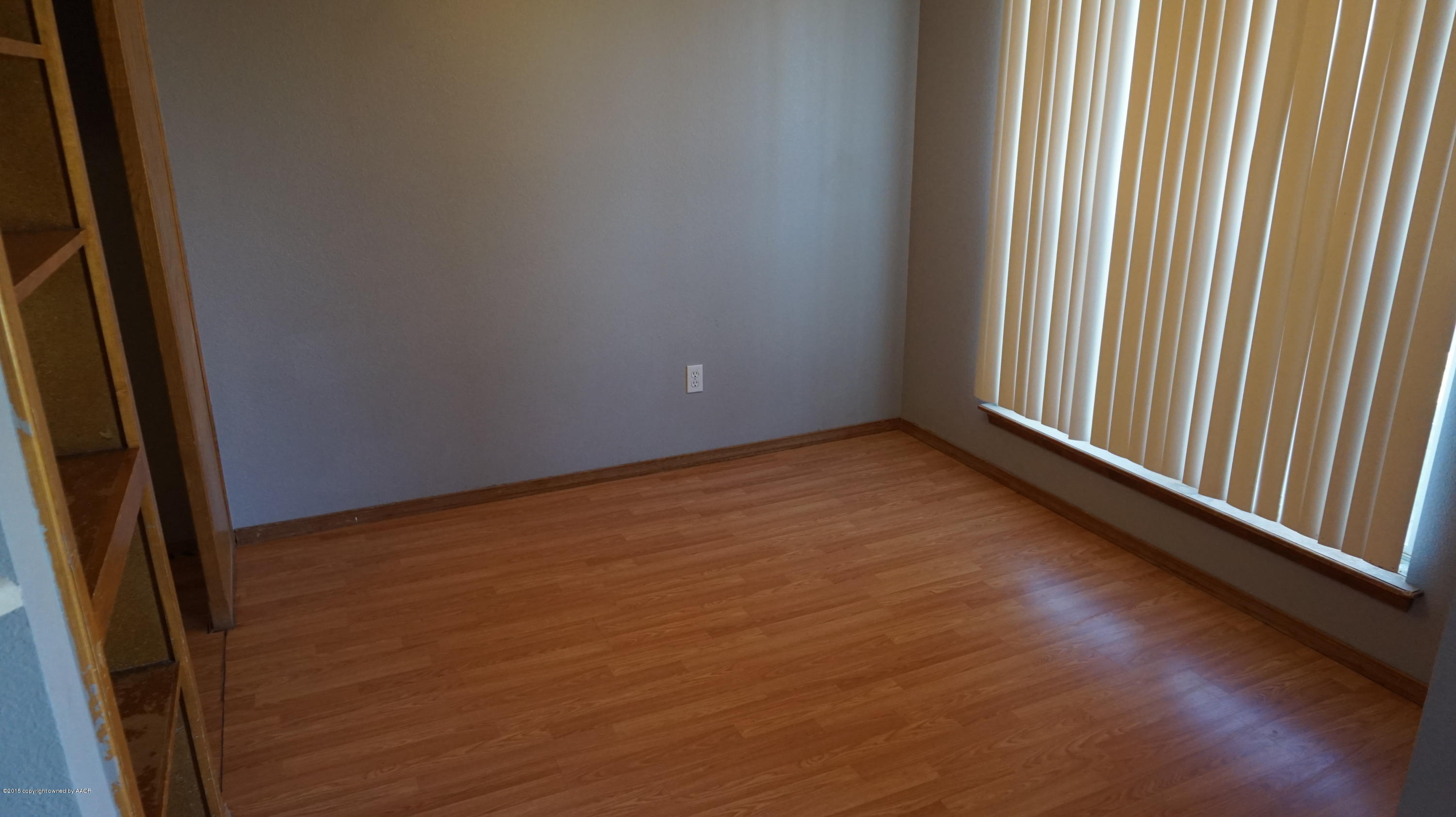 5228 Capulin Lane Amarillo, TX 79110 - Photo 6 of 16 an empty room with wooden floor and windows