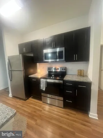 a kitchen with stainless steel appliances wooden cabinets and stove top oven