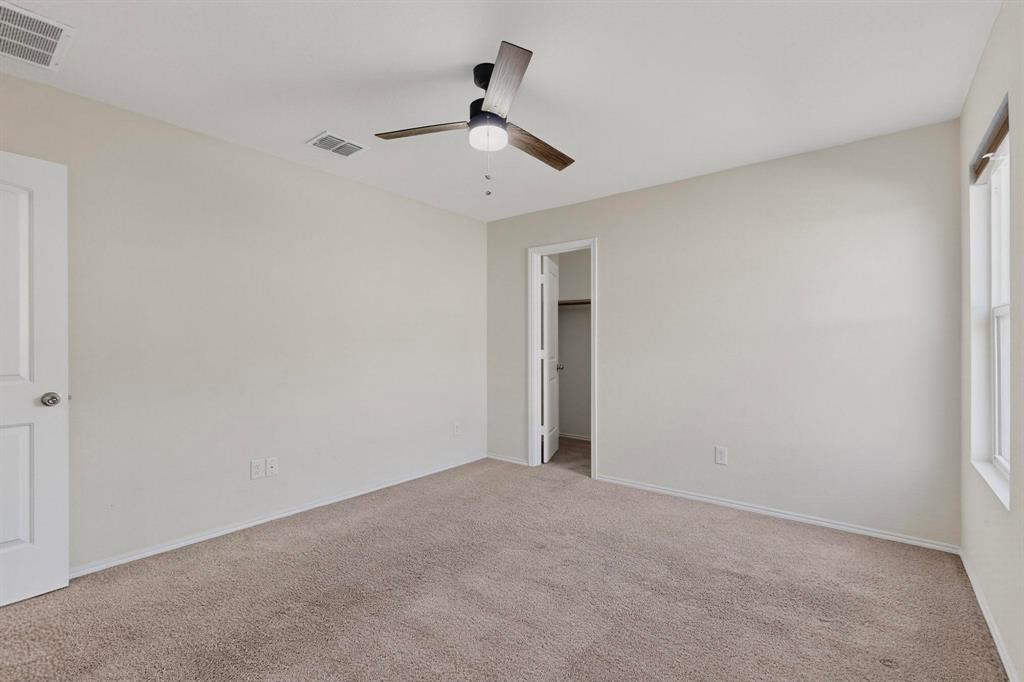 5516 McClelland Street Forney, TX 75126 - Photo 18 of 36 Unfurnished bedroom with a walk in closet, light carpet, and ceiling fan