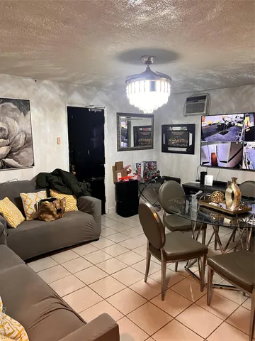 a living room with furniture kitchen view and a chandelier