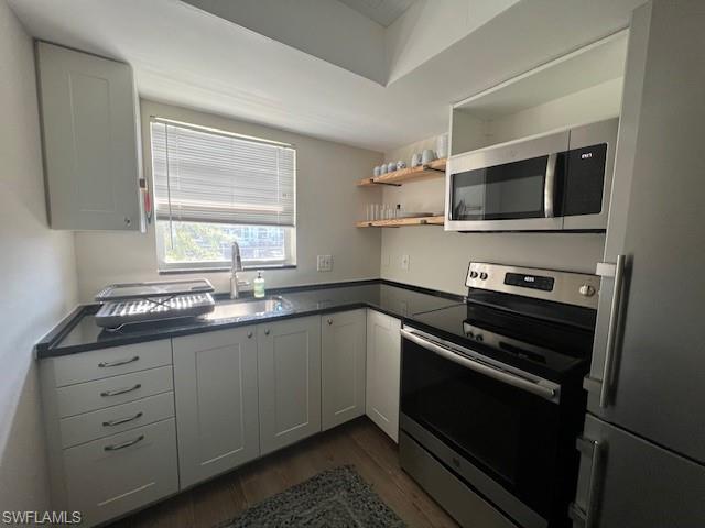 3250 10th Street North, Unit A6 Naples, FL 34103 - Photo 5 of 12 a kitchen with sink cabinets and stainless steel appliances