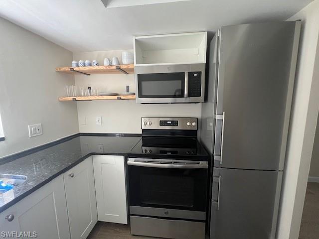 3250 10th Street North, Unit A6 Naples, FL 34103 - Photo 6 of 12 a kitchen with cabinets and steel appliances